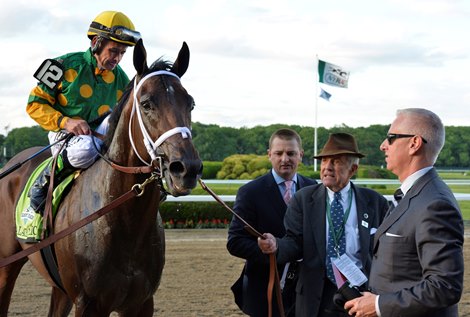 Jockey Mike Smith sits atop Palace Malice after winning  the 145th running of The Belmont Stakes June 8, 2013 at Belmont Park in Elmont, N.Y.  He is guided to the winner's circle by owner Cot Campbell, second from right and is accompanied by trainer Todd Pletcher, right and assistant trainer Mike McCarthy, third from right.