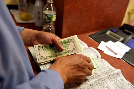 Spectators place bets before the 2018 Belmont Stakes Saturday, June 9, 2018 in Elmont, New York