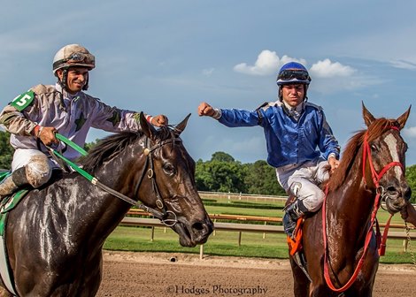 Richard Eramia (5), aboard And She Scores, celebrates a dead-heat win with Tyler Woodley, aboard Theboyzgalaxy, after the sixth race June 12 at Louisiana Downs