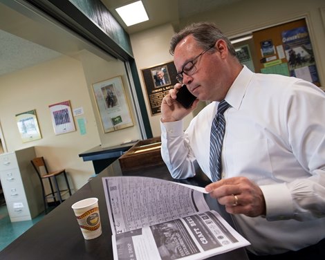 looking over program, taking a call. Ben Huffman at Keeneland on April 18, 2019 in Lexington,  Ky. <br><br />
