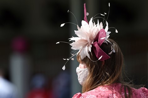 Woman wears a hat and mask. Scene on Oaks day at Churchill Downs, Louisville, KY on September 4, 2020.