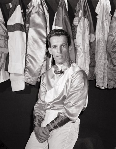 Samuel "Sam" A. Boulmetis, Sr. in front of hanging silks at Belmont Park