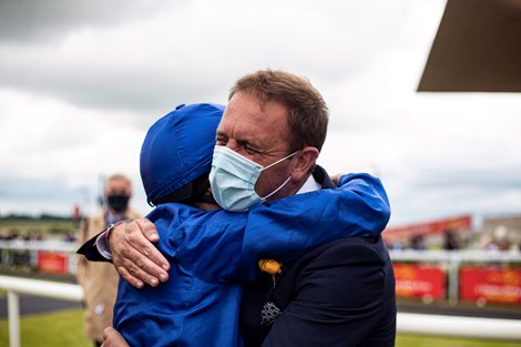 Charlie Appleby and William Buick embrace after winning the Dubai Duty Free Irish Derby with Hurricane Lane<br>
The Curragh Racecourse.<br>
26.06.2021