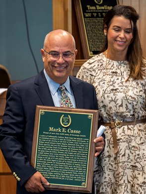 Trainer Mark Casse stands with wife Tina and holds his plaque of honor at the Hall of Fame inductions held at the Fasig Tipton sales pavilion Friday Aug 6, 2021 in Saratoga Springs, N.Y.