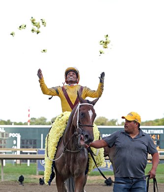 Jockey Ricardo Santana hoists flowers from the Cotillion Blanket into the air after riding Clairiere to win the $1,000,000 Grade 1 Cotillion Stakes at Parx Racing in Bensalem, Pennsylvania on September 25, 2021. Photo By Bill Denver /EQUI-PHOTO