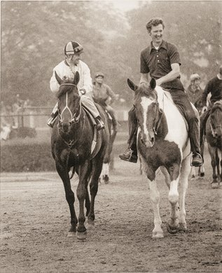 Seattle Slew with Jean Cruguet up (L) with trainer Billy Turner, Jr. on pony Steamboat (R). Seattle Slew and his team look confident as they head through the fog on the way to drill (June 2, 1977) for the $150,000 added Belmont Stakes (June 11, 1977)