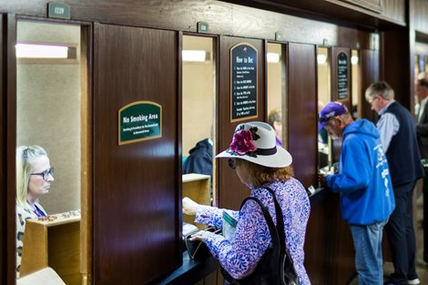 A woman places a bet at the windows in-between races during the 2022 Breeders’ Cup World Championships at Keeneland in Lexington, Ky., Saturday, November 5, 2022.