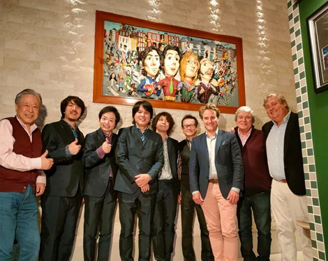 Masayuki Goto and company with a painting of The Beatles