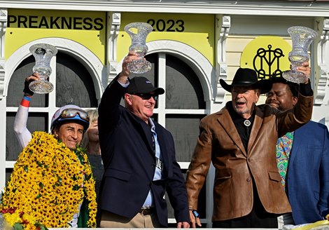 Jockey Rafael Bejarano, left, trainer Randy Morse and owner Richard Bahde hold up their winner’s trophy after their horse Taxed won the 99th running of The George E. Mitchell Black-Eyed Susan Stakes at Pimlico Race Course  Friday May 19, 2023 in Baltimore, MD.  Photo by Skip Dickstein