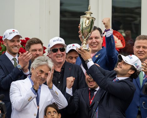 (L-R): trainer Gustavo Delgado and son Gustave Delgado Jr., holding trophy after Mage wins Kentucky Derby at Churchill Downs.