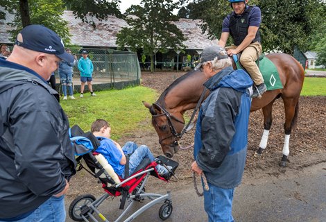 Cody Dorman meets his namesake Cody&#39;s Wish who his held by trainer Billy Mott in the barn are on the grounds of the Oklahoma Training enter adjacent to the Saratoga Race Course Friday, Aug. 4, 2023 in Saratoga Springs, N.Y.  Dorman was born with a rare genetic disorder called Wolf-Hirschhorn syndrome, leaving him unable to walk and communicate without using a tablet. In 2018, he and his family participated in a Make-A-Wish at a Kentucky farm, where a foal came up to Dorman. After Cody&#39;s Wish laid his head on Dorman&#39;s lap, a bond was born.  Photo  by Skip Dickstein