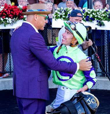Jockey Tyler Gaffalione son in law of eFive Racing’s owner Bob Edwards, left after gets a hug after riding Carl Spackler to the win in  the 39th running of The National Museum of Racing Hall of Fame stake at the Saratoga Race Course Friday Aug. 11, 2023 in Saratoga Springs, N.Y. Photo  by Skip Dickstein