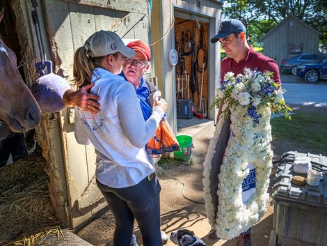 Trainer Brendan Walsh, center hugs trainer Melanie Giddings as Walsh’s assistant, Charley Lynch presents Giddings with the Winner’s blanket from The Test Stakes in the barn area at the Oklahoma Training Center adjacent to the Saratoga Race Course Sunday, Aug. 6, 2023 in Saratoga Springs, N.Y. Photo  by Skip Dickstein