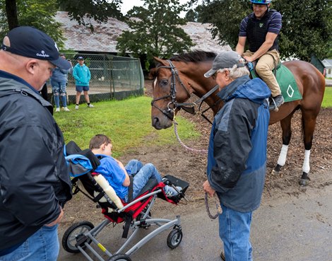 Cody Dorman meets his namesake Cody&#39;s Wish who his held by trainer Billy Mott in the barn are on the grounds of the Oklahoma Training enter adjacent to the Saratoga Race Course Friday, Aug. 4, 2023 in Saratoga Springs, N.Y.  Dorman was born with a rare genetic disorder called Wolf-Hirschhorn syndrome, leaving him unable to walk and communicate without using a tablet. In 2018, he and his family participated in a Make-A-Wish at a Kentucky farm, where a foal came up to Dorman. After Cody&#39;s Wish laid his head on Dorman&#39;s lap, a bond was born.  Photo  by Skip Dickstein