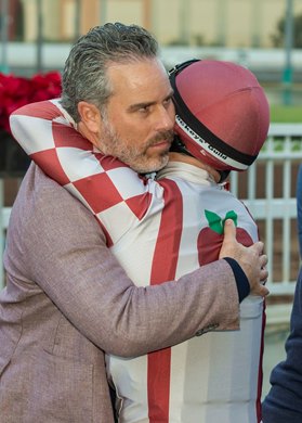 Aron Wellman or Eclipse Thoroughbred Partners, left, has a hug for jockey Umberto Rispoli, right, after Journalism&#39;s victory in the Grade II, $200,000 Los Alamitos Futurity, Saturday, December 14, 2024 at Los Alamitos Race Course, Cypress CA.<br><br />
&#169; BENOIT PHOTO