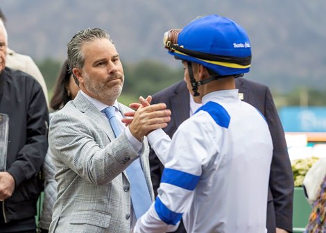 Aron Wellman or Eclipse Thoroughbred Partners, left, celebrates with jockey Jose Ortiz, right, in the winner's circle after Locked's victory in the  Grade I, $300,000 Santa Anita Handicap, Saturday, March 1, 2025 at Santa Anita Park, Arcadia CA.<br>
© BENOIT PHOTO