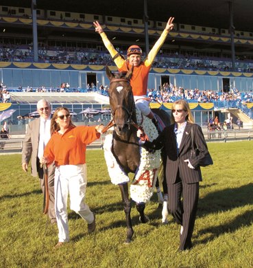 Toronto Ont.Sept19_04.Woodbine Racetrack.Sam-Son Farm's Soaring Free captures the $1,000,000 Atto Mile.(l-r)Trainer Mark Frostad ,jockey Todd kabel and owner Tammy Samuel lead the horse after the gutsy performance. michael burns photo