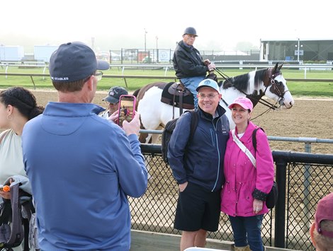 Fans take a photo with Trainer D. Wayne Lukas as a backdrip during morning workouts at Pimlico on Friday morning.  Photo By Bill Denver/MJC