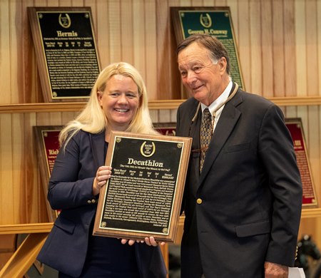 Cate Master, director presents the plaque to Alfred Nichols, accepting for Decathlon at the Hall of Fame inductions held at the Fasig Tipton Sales Pavilion Friday August 1, 2025 in Saratoga Springs, N.Y.  Skip Dickstein Photo